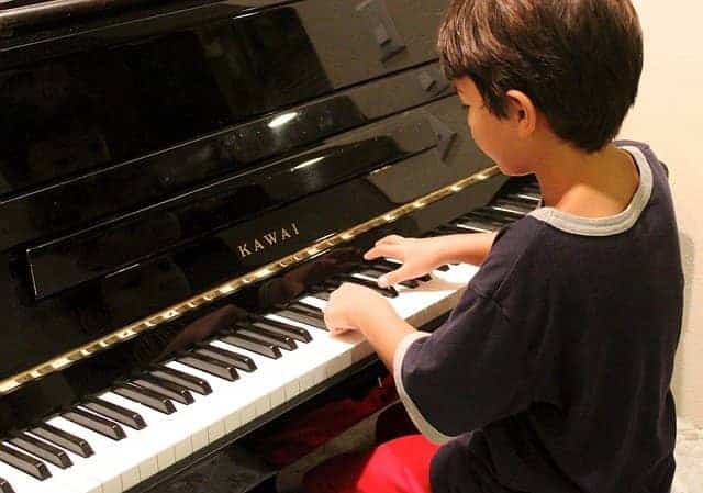 Kind leert piano spelen