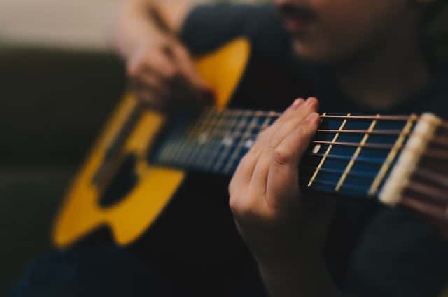 Man speelt akoestisch gitaar voor beginners