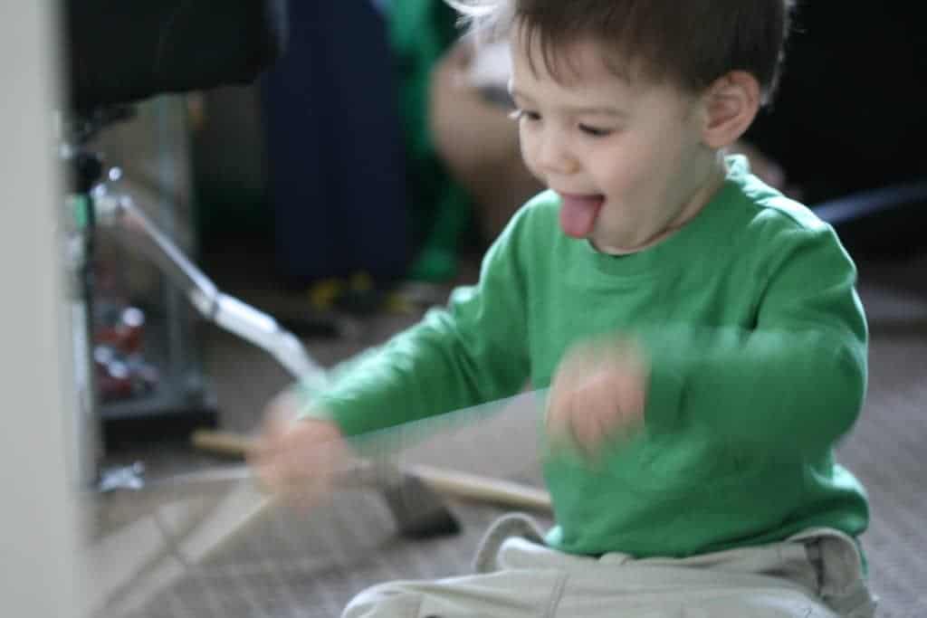 Klein jongetje leert drummen op elektronisch drumstel