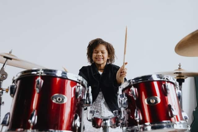 Meisje leert drummen op drumstel